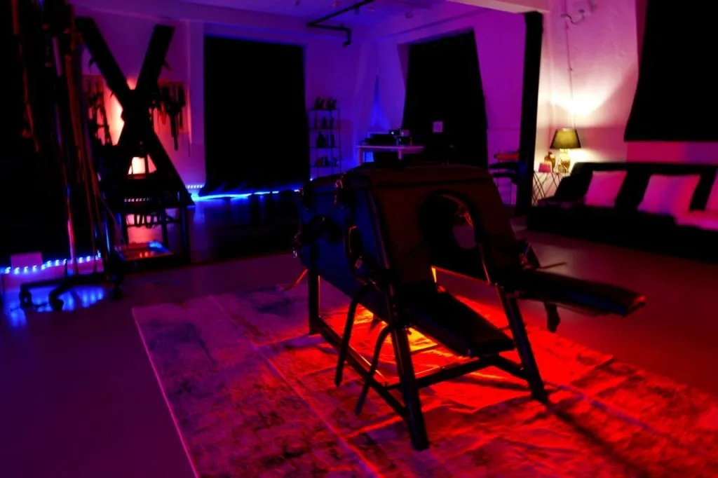 The open-plan dungeon of the BDSM Penthouse at Tower Bridge, London, lit in violet and red